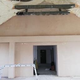 MARBUD - MARIAN SKOTNIK - Świeżo otynkowane poddasze z widoczną izolacją piankową, drabina aluminiowa w pomieszczeniu z przygotowanym otworem drzwiowym.