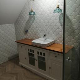 MARBUD - MARIAN SKOTNIK - Łazienka w skosie z białymi płytkami w kształcie rybiej łuski, drewnianą szafką pod umywalką i podłogą ułożoną w jodełkę.