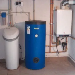 Instalacja kotła gazowego, zasobnika ciepłej wody i zmiękczacza wody w kotłowni z ceramiczną podłogą.