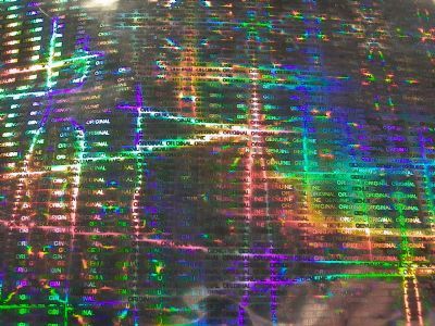 Holograficzna folia z powtarzającym się napisem 'ORIGINAL' i efektem tęczy, przeznaczona na naklejki, etykiety lub plomby.