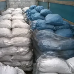 Załadunek workowanego koksu: białe i niebieskie worki ułożone w rzędach w przestrzeni ładunkowej pojazdu.