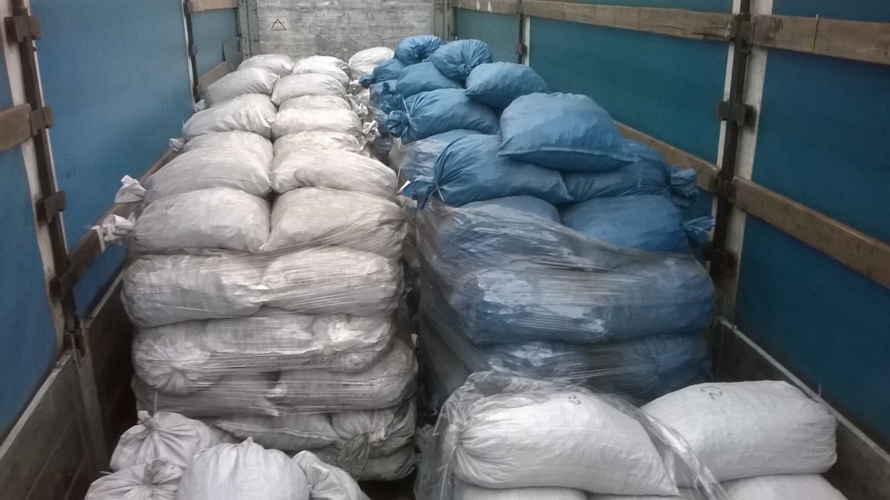 Załadunek workowanego koksu: białe i niebieskie worki ułożone w rzędach w przestrzeni ładunkowej pojazdu.