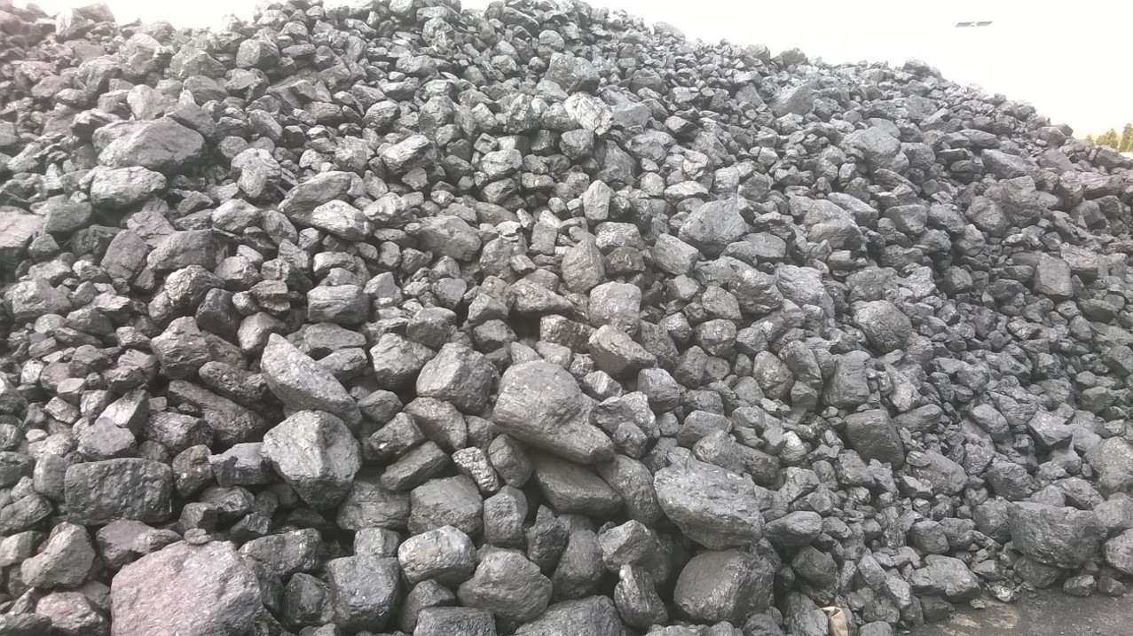 Kopalniany węgiel orzech KWK Marcel ułożony w pryzmę, widoczne pojedyncze bryły o nieregularnych kształtach i błyszczącej powierzchni.