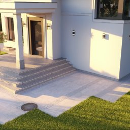 Pil-dom,Paweł Subotkiewicz - Nowoczesny dom z jasną elewacją, schodami z szarego granitu i wyłożonym płytami tarasem. Oświetlenie zewnętrzne podkreśla architekturę budynku.