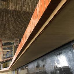 Techmax - Wnętrze budynku po malowaniu, widoczne ślady farby na oknach i ścianach, ceglany sufit.