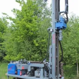 Wiertnica kręgowa marki Krebs, ustawiona na podwoziu gąsienicowym, na tle zieleni.