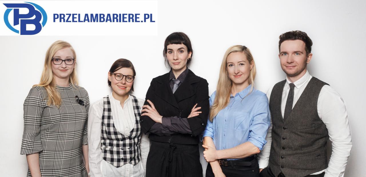 Grupa pięciu osób w różnym wieku, ubranych w formalne stroje, stojących na tle białej ściany, z widocznym logo firmy 'Przelambariere.pl' w górnej części zdjęcia.