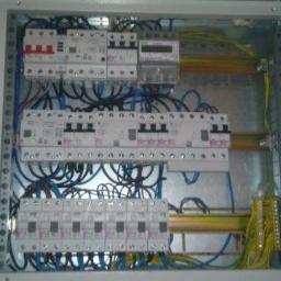 el4you - Rozdzielnica elektryczna z zainstalowanymi bezpiecznikami, licznikiem i okablowaniem w skrzynce metalowej, widok z góry.