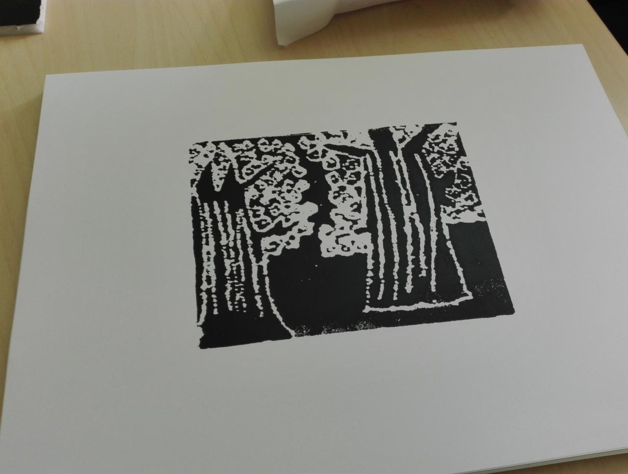 Czarno-biała grafika przedstawiająca stylizowany las, wykonana techniką linorytu na białym papierze, ukazująca kontrastowe drzewa z gęstymi koronami.