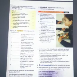 Ekran komputera z otwartym oknem wideokonferencji z lektorem języka angielskiego z Gdańska, obok widoczny podręcznik do nauki angielskiego z ćwiczeniami gramatycznymi.