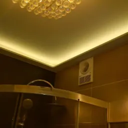 Ukończona łazienka z kabiną prysznicową, oświetleniem LED i ozdobnym żyrandolem z kryształowych kul.