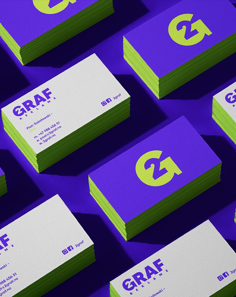 Stos wizytówek z logo '2G' na fioletowym tle. Wizytówki w odcieniach fioletu i limonki, z danymi kontaktowymi. Układ w regularnym wzorze, ostre cienie.