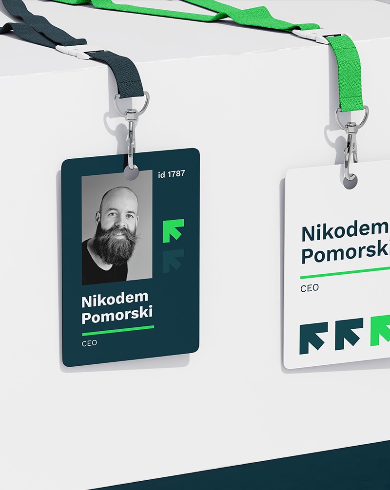 Dwa identyfikatory wizualne CEO Nikodema Pomorskiego. Jeden w kolorze ciemnozielonym ze zdjęciem, drugi biały z logo. Zawieszki na smyczach w kolorach zieleni i granatu.