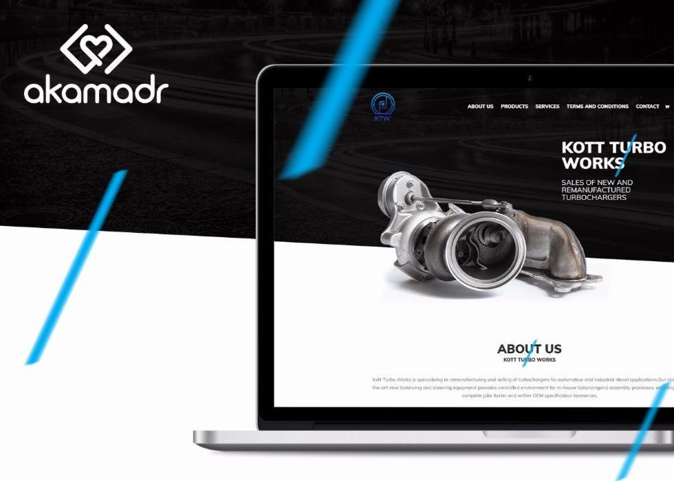 Laptop wyświetla stronę internetową firmy Kott Turbo Works z turbosprężarką na pierwszym planie, logo firmy akamadr widoczne w lewym górnym rogu.