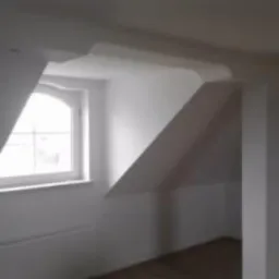 Białe, gładkie ściany i sufit na poddaszu z oknem łukowym, widoczne elementy konstrukcyjne po gładziowaniu i malowaniu.