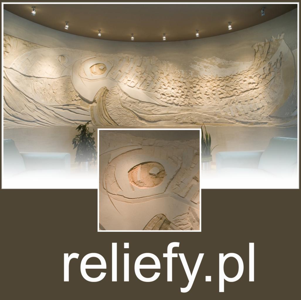 Duży, jasny relief ścienny przedstawiający stylizowany statek na falach, oświetlony punktowymi lampami sufitowymi w tle widać fragment białej sofy i roślinę doniczkową.