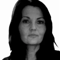 Portret kobiety z długimi, ciemnymi włosami, skierowanej twarzą do widza, na jasnym tle.