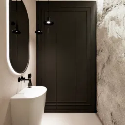 Minimalistyczna łazienka z owalnym lustrem podświetlonym LED, białą umywalką wolnostojącą, czarną armaturą i dwoma czarnymi lampami wiszącymi na tle ciemnych, panelowych drzwi i ściany z efektem...