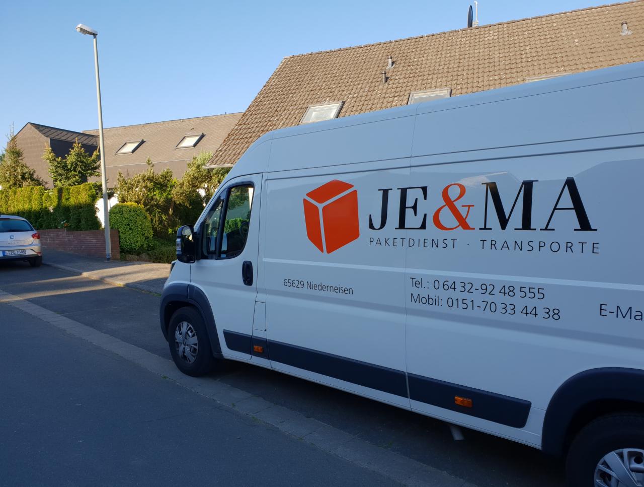 Biała furgonetka z pomarańczowym logo JE&MA, zaparkowana na ulicy w Niemczech, z numerem telefonu i adresem 65629 Niederneisen.