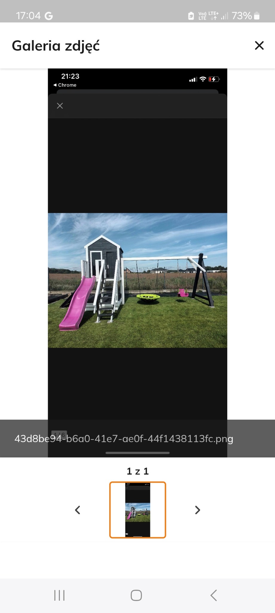 Kompleksowy plac zabaw na trawniku: drewniany domek ze zjeżdżalnią, huśtawka typu bocianie gniazdo i tradycyjna huśtawka. Tło stanowi błękitne niebo.