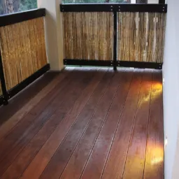 Drewniany taras z egzotycznego drewna bangkirai, balustrada z elementami bambusowymi, oświetlenie punktowe w podłodze.