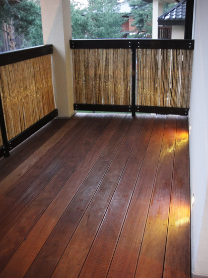 Drewniany taras z egzotycznego drewna bangkirai, balustrada z elementami bambusowymi, oświetlenie punktowe w podłodze.