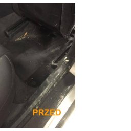 Komplex Styl Jan Bereś - Wnętrze samochodu przed czyszczeniem: brudna podłoga i wykładzina z widocznymi okruchami, kurzem i plamami, fragment fotela obok, napis 'PRZED' w dolnym rogu.