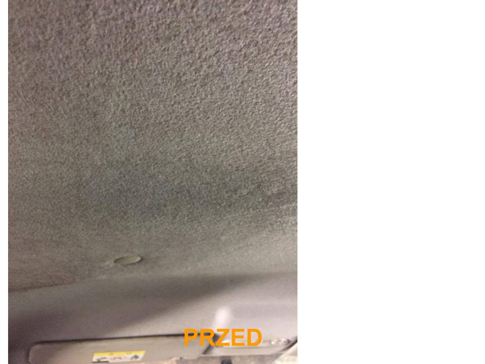 Szara podsufitka samochodu w stanie zabrudzonym, widoczny fragment osłony przeciwsłonecznej.