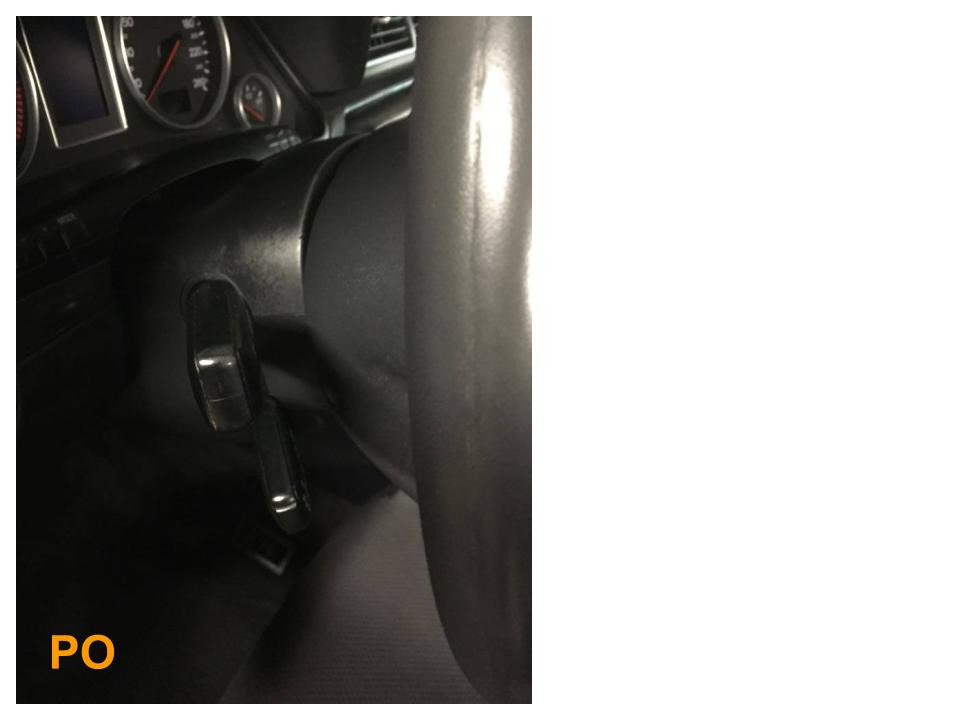 Wnętrze samochodu, fragment kierownicy i deski rozdzielczej w słabym oświetleniu.