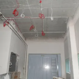 Wnętrze w Kamesznicy w trakcie prac: widoczne kable elektryczne prowadzone po suficie i ścianach, przygotowane do dalszej instalacji.