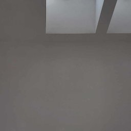 P&m bud - Gładka, szara ściana z dwoma oknami dachowymi z drewnianymi ramami, przez które widać błękitne niebo.