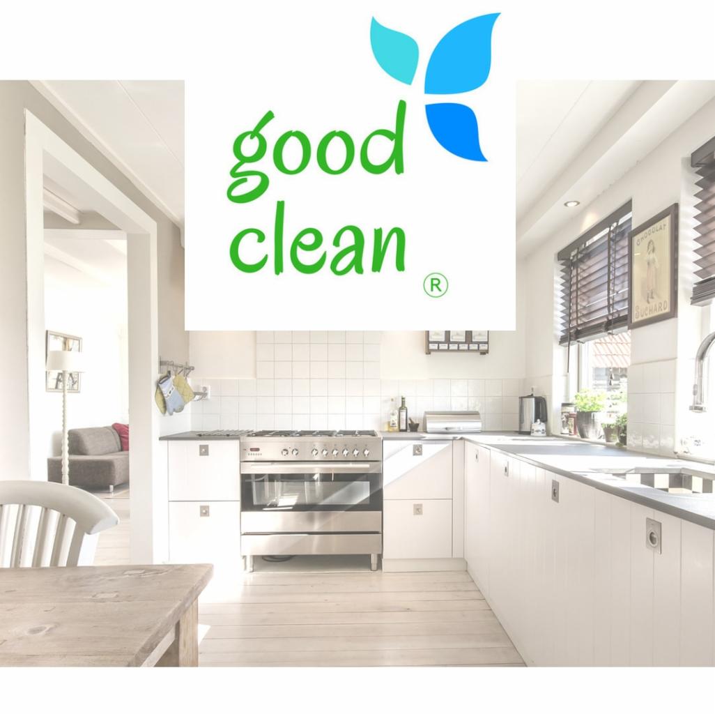 Logo firmy sprzątającej Good Clean na tle jasnej, czystej kuchni z białymi szafkami i drewnianą podłogą.