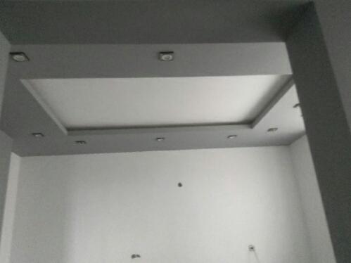 Szary sufit podwieszany z wbudowanym oświetleniem punktowym w nowym pomieszczeniu, widok z dołu.