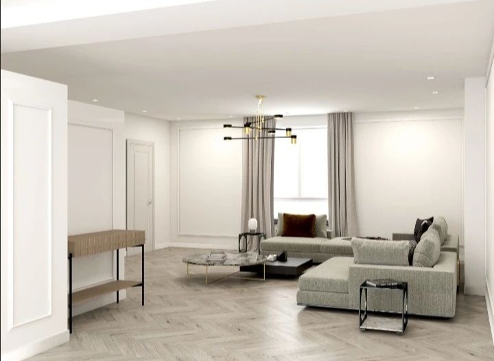 Jasne, przestronne wnętrze salonu z narożną sofą modułową, marmurowym stolikiem kawowym na złotych nóżkach i nowoczesną lampą wiszącą z elementami złota.