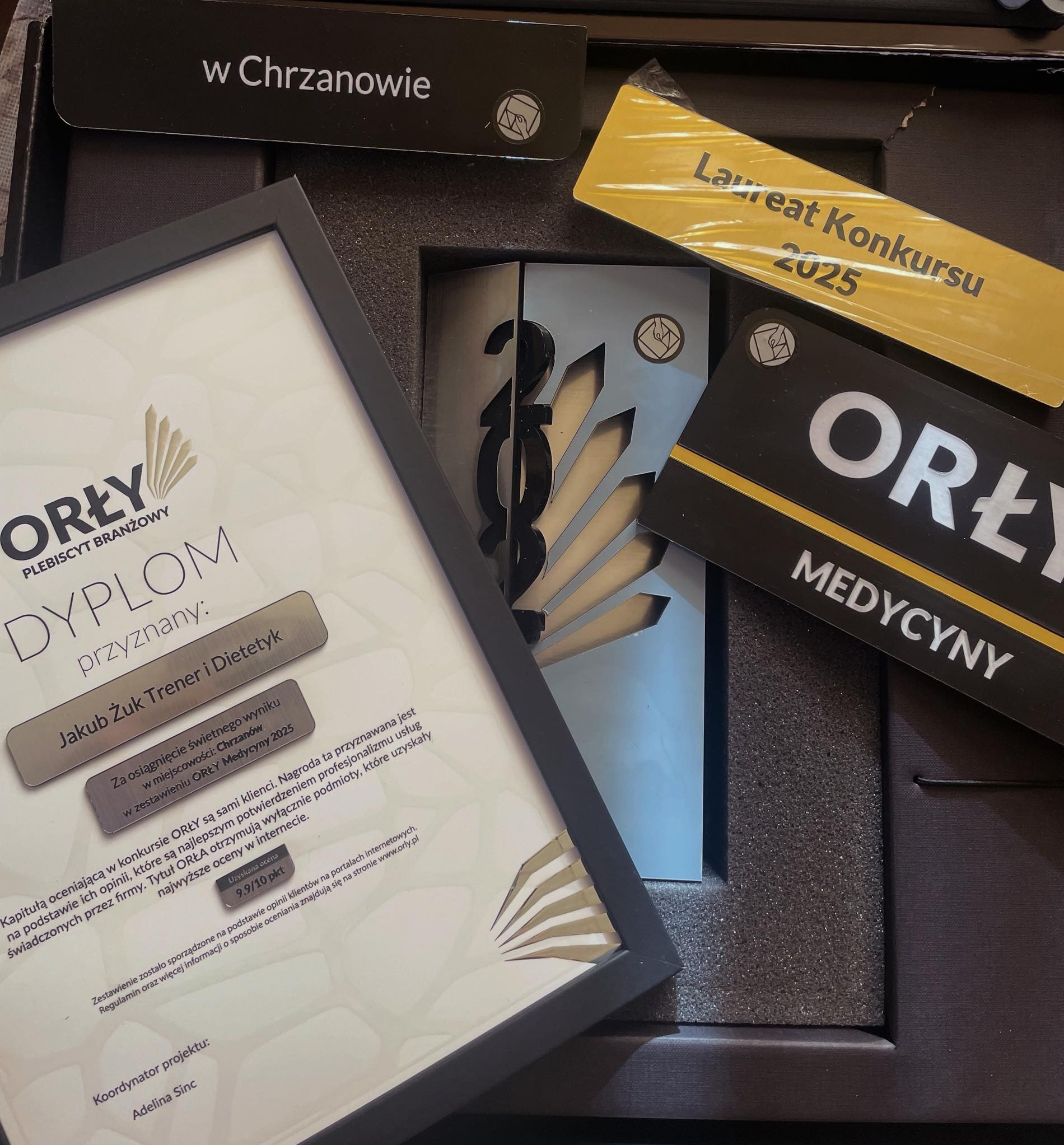 Dyplom 'Orły Medycyny 2025' dla Jakuba Żuka, trenera i dietetyka z Chrzanowa, za wysokie oceny klientów. Nagroda w czarnym pudełku z logo i napisem 'Laureat Konkursu 2025'.