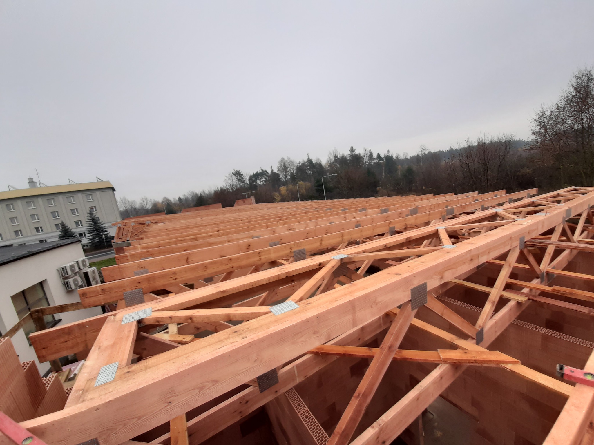 Wiązary dachowe z drewna, połączone metalowymi płytkami, na murach z pustaków ceramicznych, widok z góry, Żory.