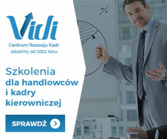 Prelegent w garniturze gestykuluje podczas prezentacji diagramu kołowego na flipcharcie, logo firmy szkoleniowej w lewym górnym rogu.