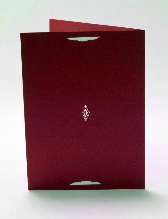 Otwarty, bordowy folder z delikatnym, srebrnym ornamentem na okładce, widoczne wycięcia na zamknięcie.