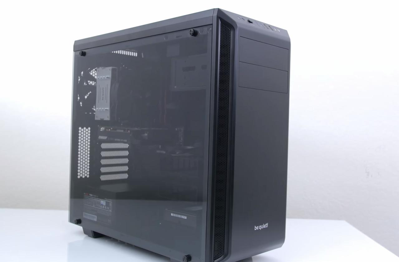 Czarna obudowa komputera PC marki be quiet! z przeszklonym panelem bocznym, ukazującym wnętrze z zamontowanymi komponentami, na białym tle.