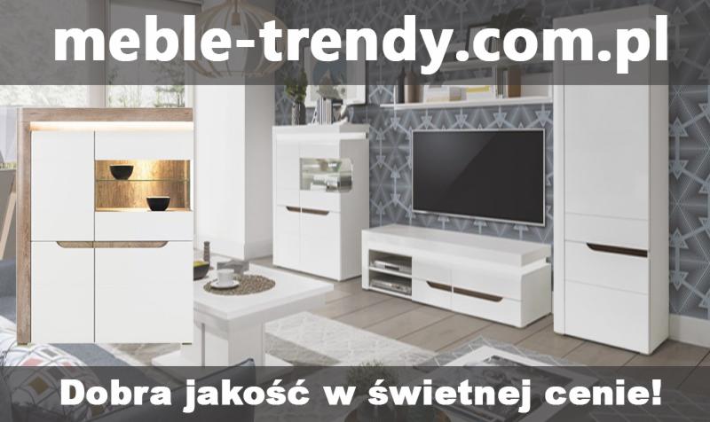 Biała meblościanka z witrynami, szafką RTV i szafą, na tle geometrycznej tapety i jasnej podłogi, z widocznym adresem strony internetowej i hasłem reklamowym.