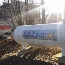 Biały zbiornik na gaz z napisem GAZpetrol, zamontowany na betonowych podstawach w Czechowicach-Dziedzicach, z widocznym samochodem dostawczym w tle.