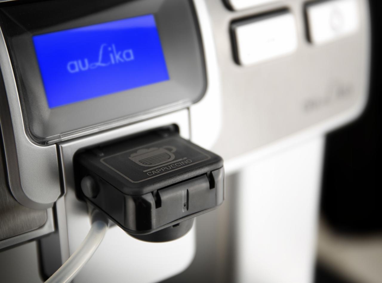 Szczegółowy widok automatycznego ekspresu do kawy z wyświetlaczem LCD pokazującym napis 'au Lika' i przyciskiem wyboru cappuccino.