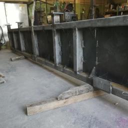 Oliweld - Spawana konstrukcja stalowa z profili zamkniętych, podparta drewnianymi klockami, widoczna w warsztacie.