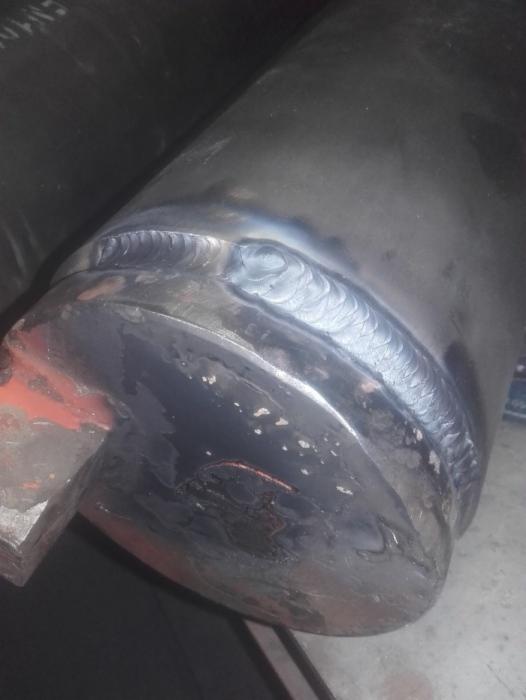 Spoina na metalowej rurze, widoczna struktura spawu, zarysowania i ślady użytkowania na powierzchni.