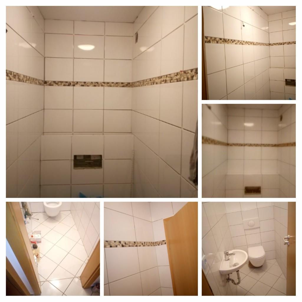 Wykończona łazienka z białymi płytkami i dekoracyjnym pasem mozaiki, widok na kabinę prysznicową, umywalkę i toaletę.