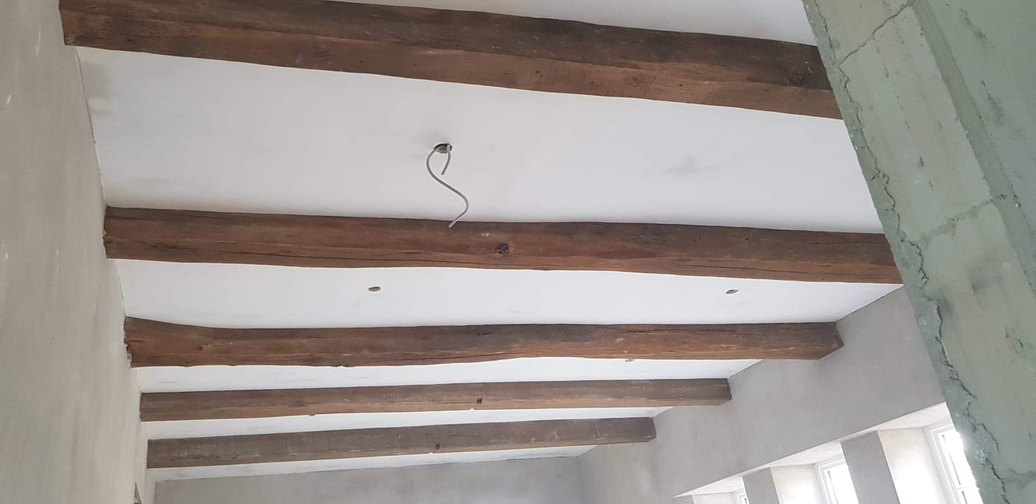 Sufit GK wykonany między konstrukcją drewnianą domu w salonie wraz z otworami na lampy i szpachlowaniem Q3