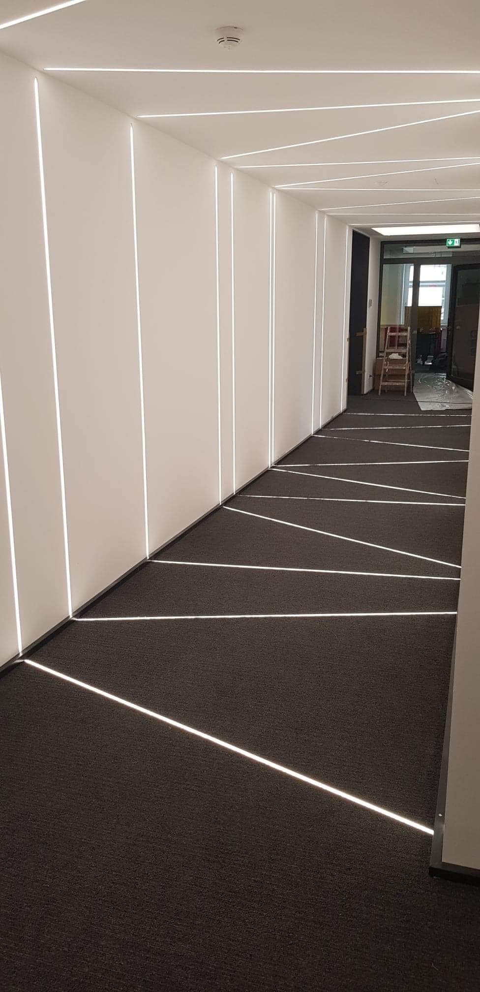 Oświetlenie korytarza,ściany w systemie GK, ledy w listwach alu zamontowane na równi z płaszczyzną sciany i podłogi