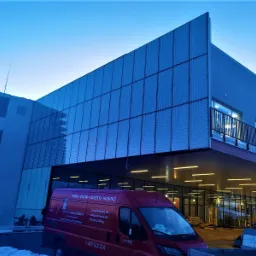 Fasada hotelu Crystal Mountain w Wiśle z nowoczesnymi żaluzjami zewnętrznymi, widoczny firmowy samochód dostawczy na pierwszym planie.