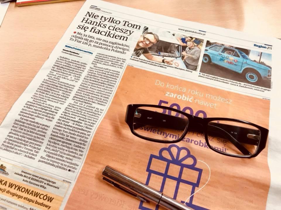 Gazeta Lubuska z artykułem o Fiacie 126p, okularami i długopisem na stole