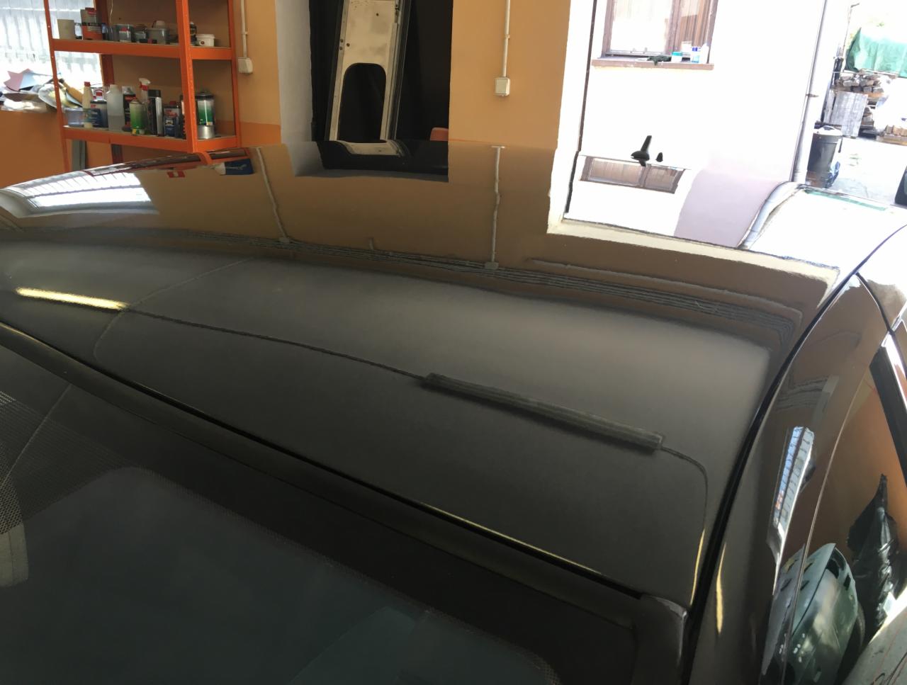 Błyszczący, czarny dach samochodu po renowacji w warsztacie w Miliczu, widoczne odbicia otoczenia.